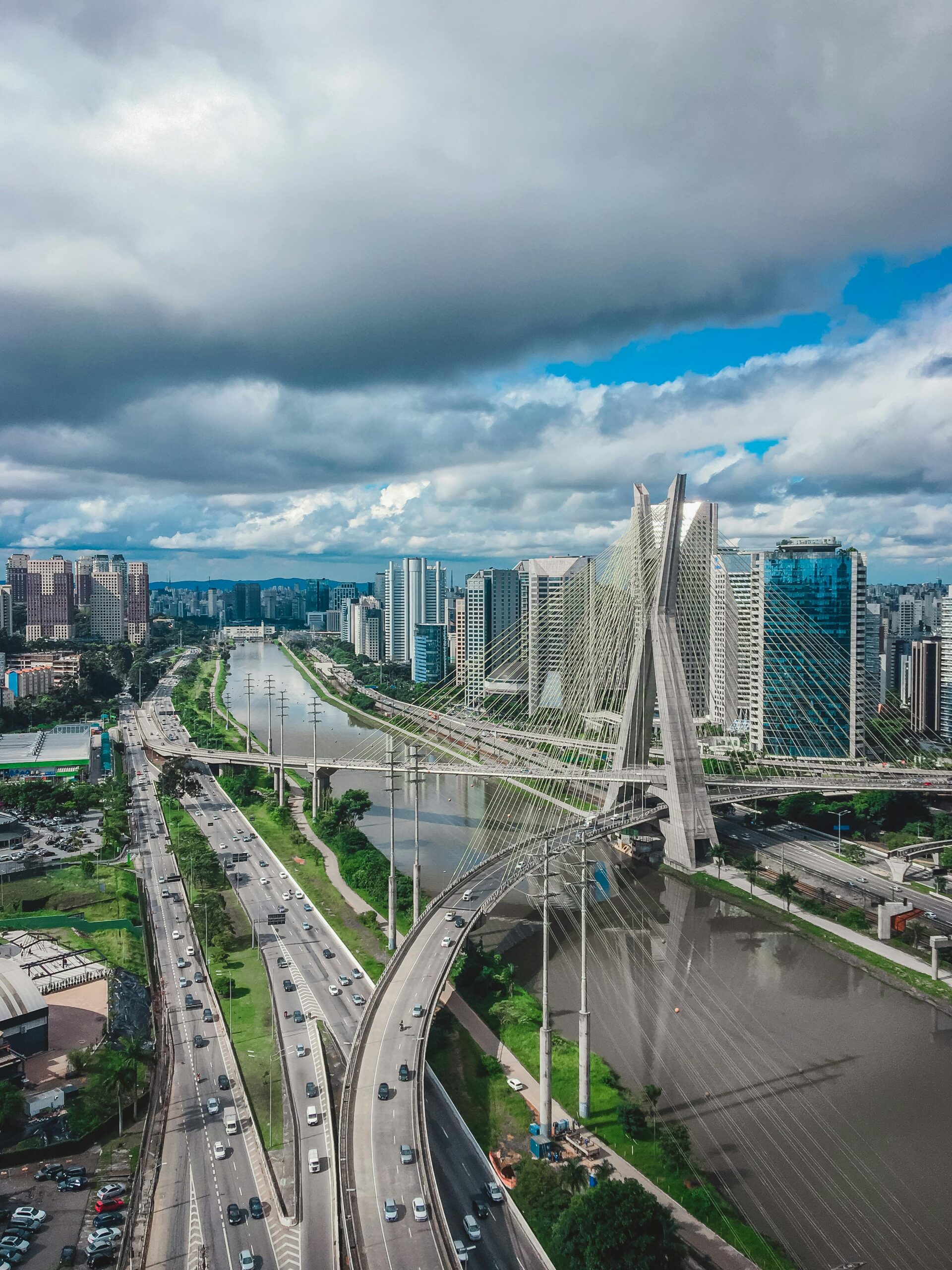 Aerial view of São Paulo featuring the iconic Ponte Estaiada and urban skyline under a cloudy sky.